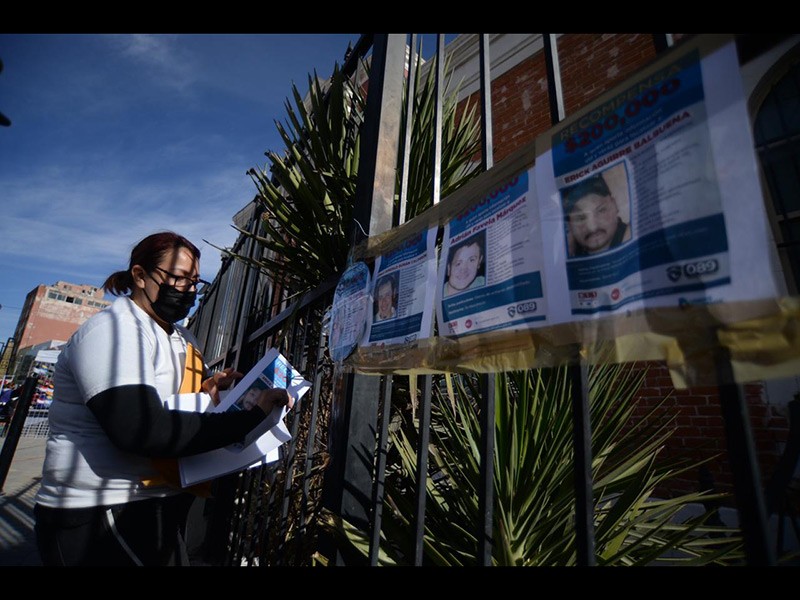 Familiares colocan pesquisas de desaparecidos durante el acto celebrado frente al Muref.