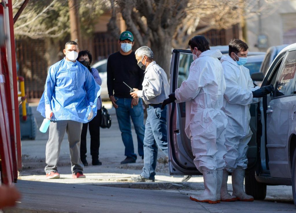 Funerarios esperan afuera del área Covid
