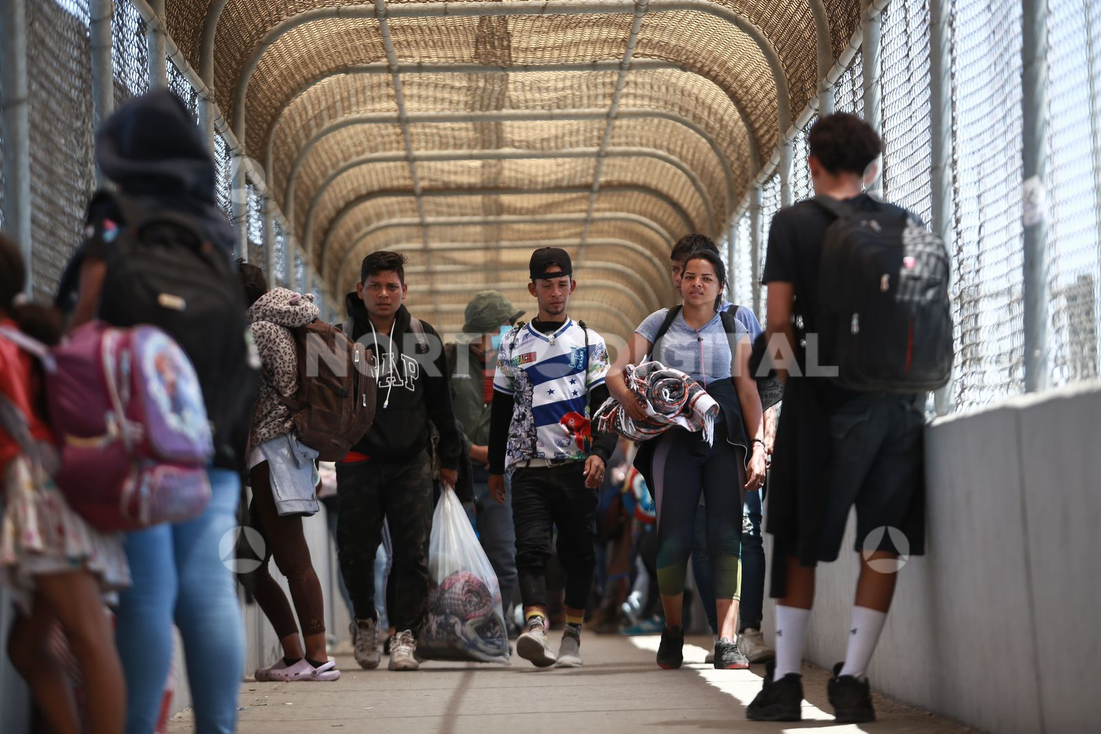 Migrantes llenan el paso peatonal del Puente libre - Norte de Ciudad Juárez